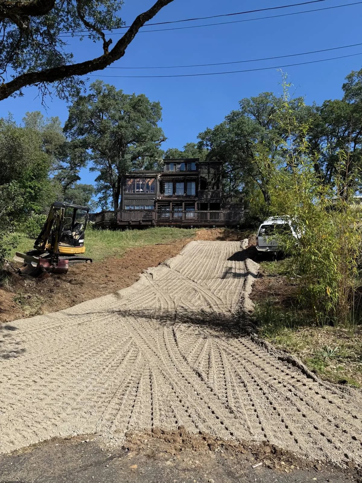 An excavator and dump truck working on a freshly graded site