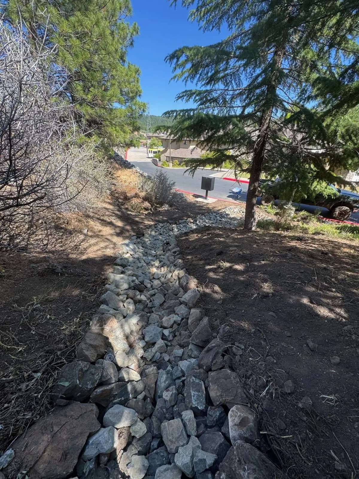 Cleared hillside with a rock-lined drainage channel